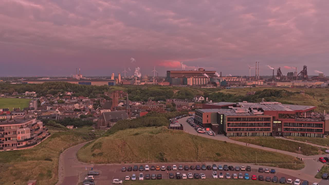 Dronebillede af den hollandske kystby Wijk aan Zee med et stålværk i nærheden.