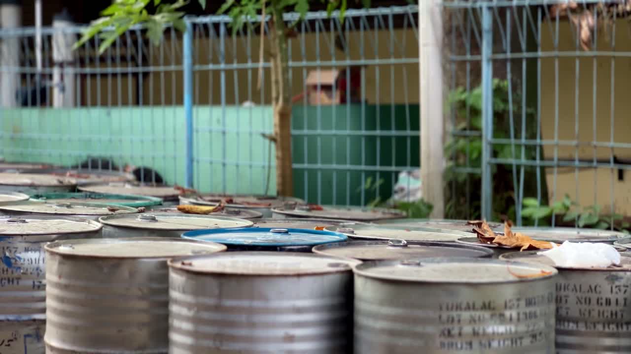 Rows of Metal Industrial Barrels in an Outdoor Storage Area