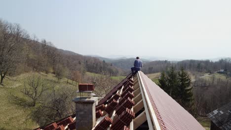 Drone-Footage-of-Construction-Worker-Installing-Roof-Shingles