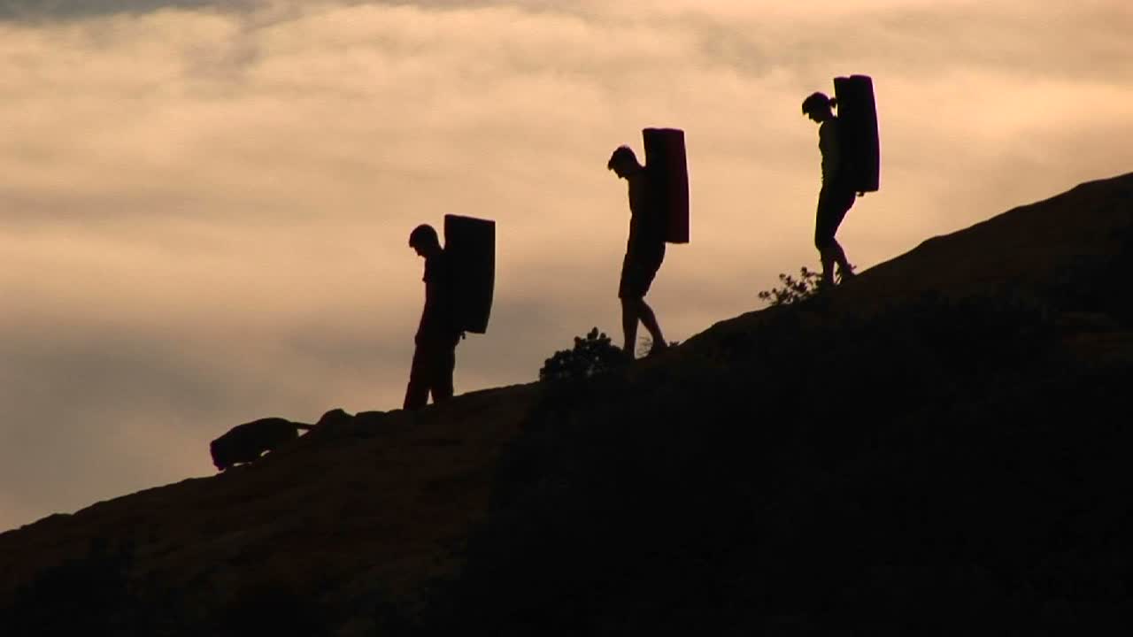 세 명의 백패커와 저녁 하늘을 배경으로 한 개 실루엣의 왼쪽 팬