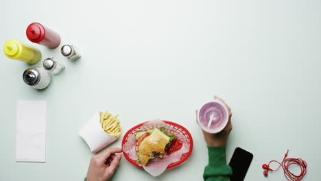 Vista-Superior-Hombre-Comiendo-Hamburguesa-En-Restaurante-De-Comida-Rápida-Americano-Manos-Desde-Arriba---Dragón-épico-Rojo