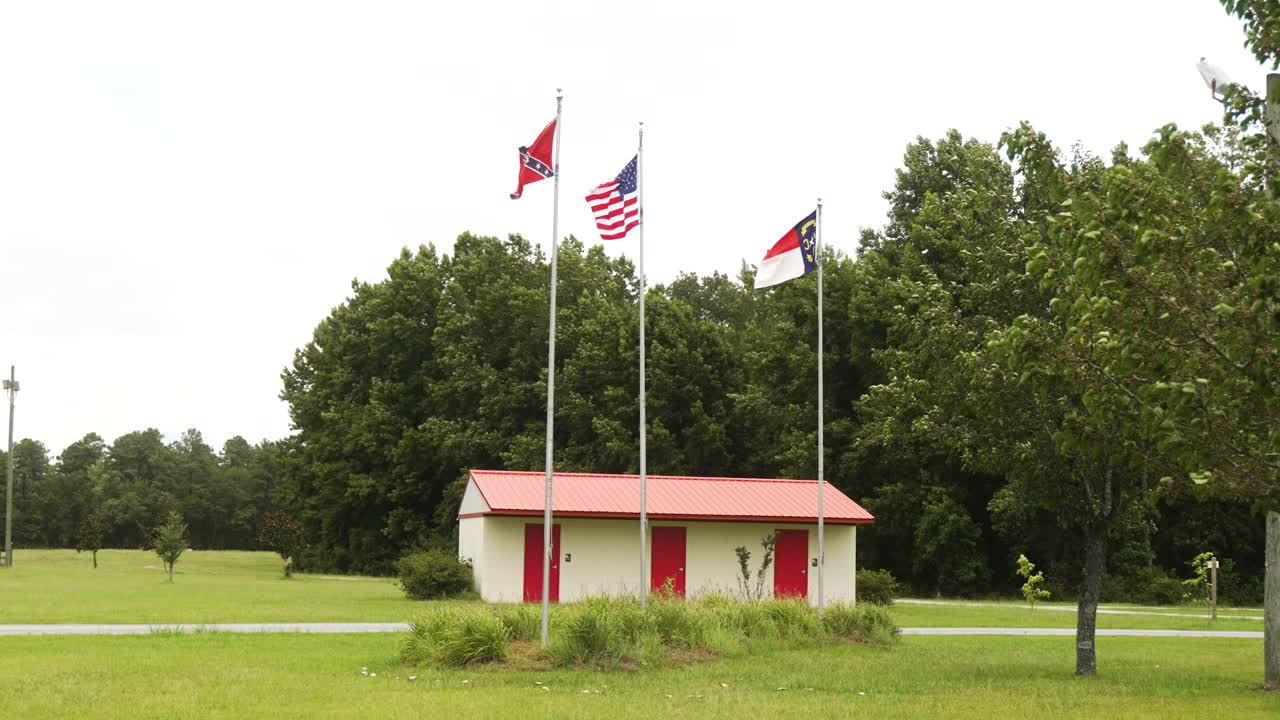 Civil War battle site with the USA, Confederate, and North Carolina state flags blowing in the wind