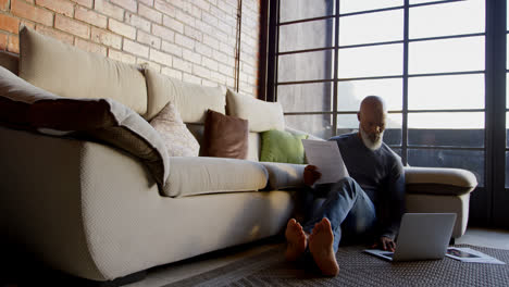 senior man using laptop in living room 4k