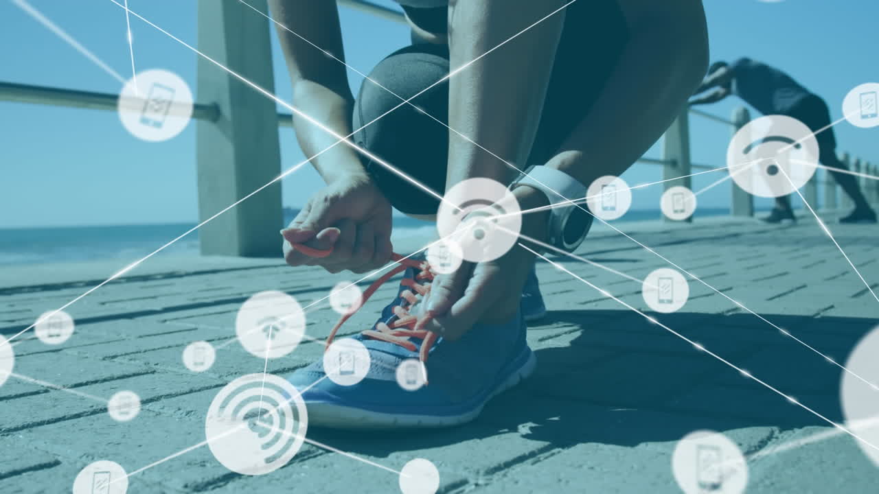 Network of connection icons against woman tying her shoelaces