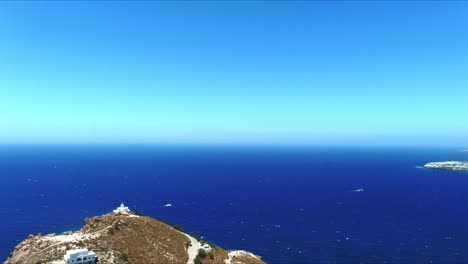 aerial 4k blue sea and sky top view over house and akrotiri lighthouse in santorini greece