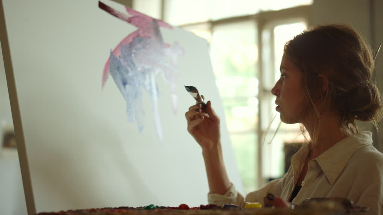 캔버스에 페인트를 칠하는 창의적인 여성. 화가 실내에서 그림을 그리고 있습니다.