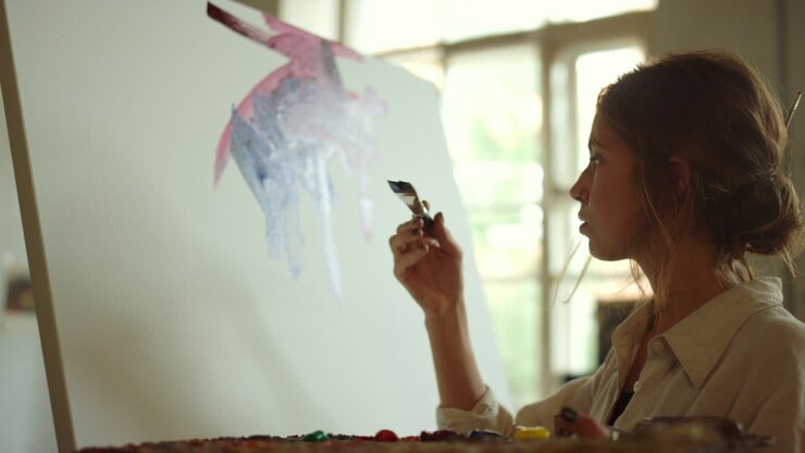 Creative woman applying paint on canvas. Painter drawing picture indoors.