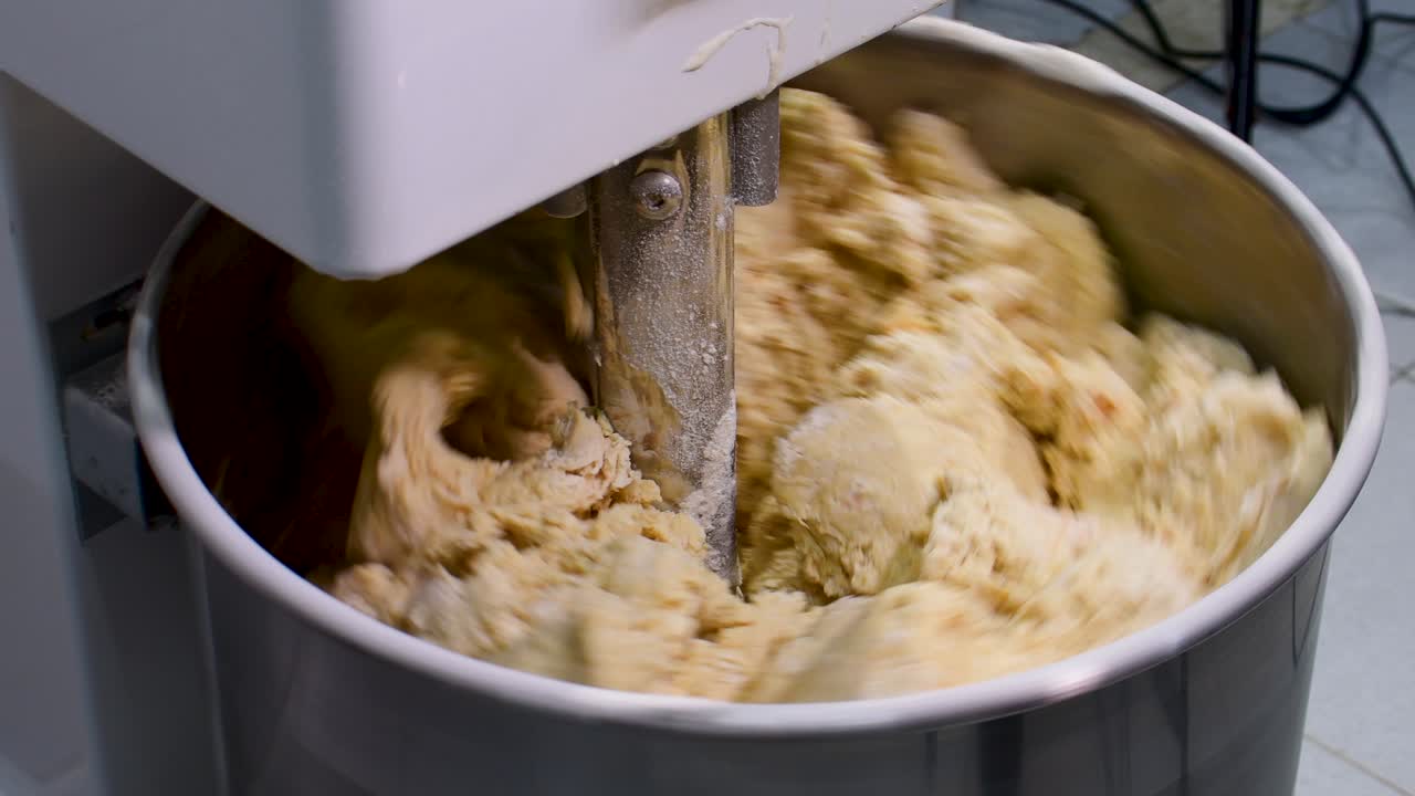Close up detail of industrial dough mixer elaborating raw pastry dough