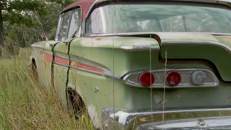 an old ford edsel sits in a field 8