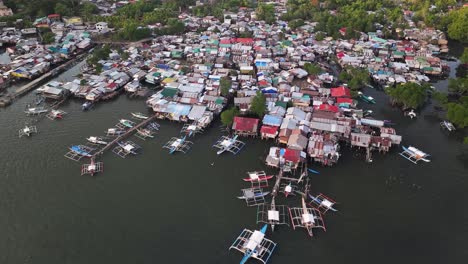 slum on water, small fishing village in coron, philippines. drone tilt down from panorama.