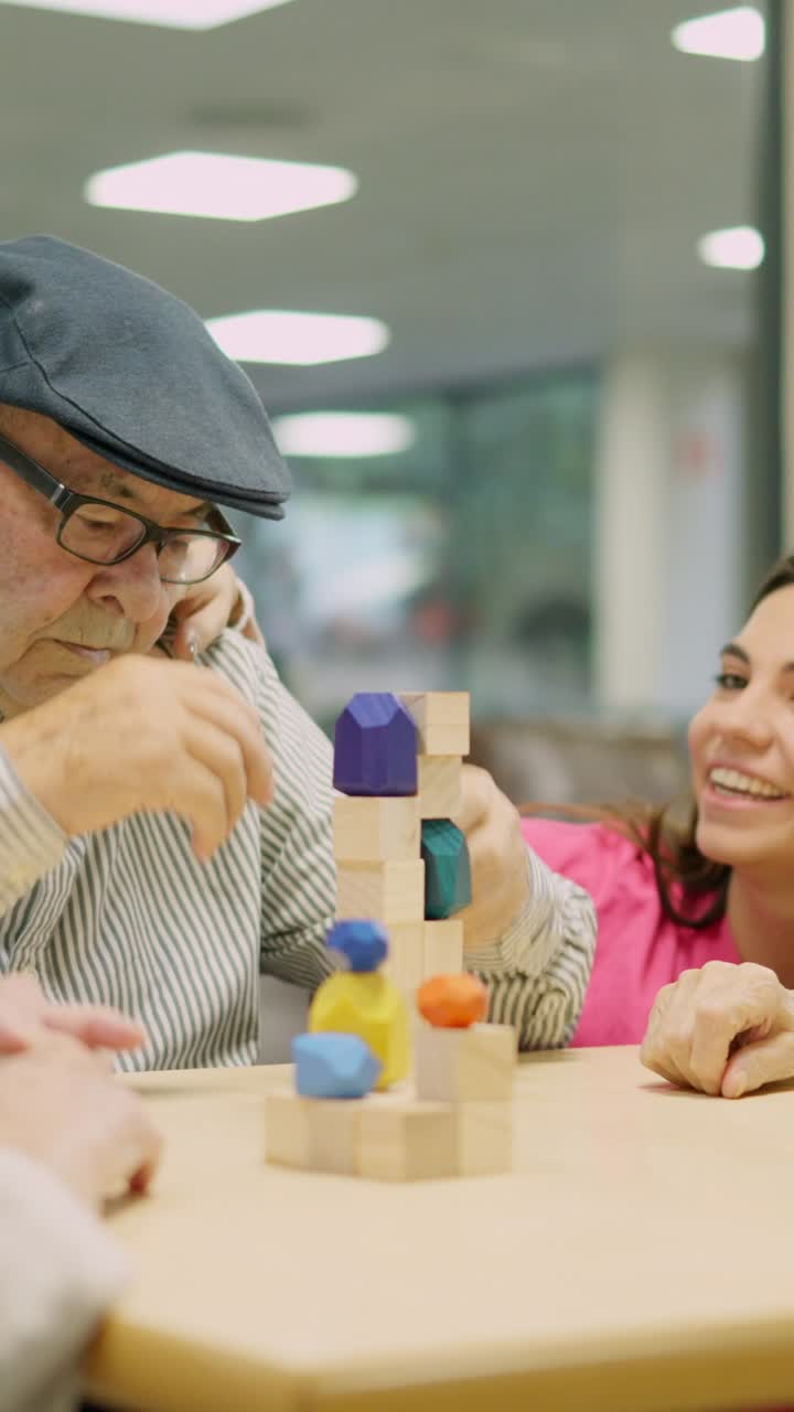 Elderly man and young woman playing with building blocks