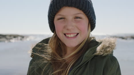 Close-Up-Retrato-De-Niña-Feliz-En-La-Playa-Sonriendo-Alegre-Vestido-Cálido