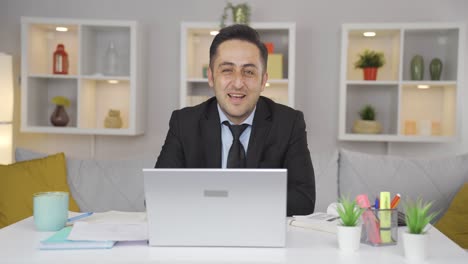 el trabajador de oficina en casa hace un guiño a la cámara.
