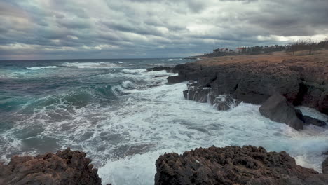 waves crashing on a rocky coast under a cloudy sky