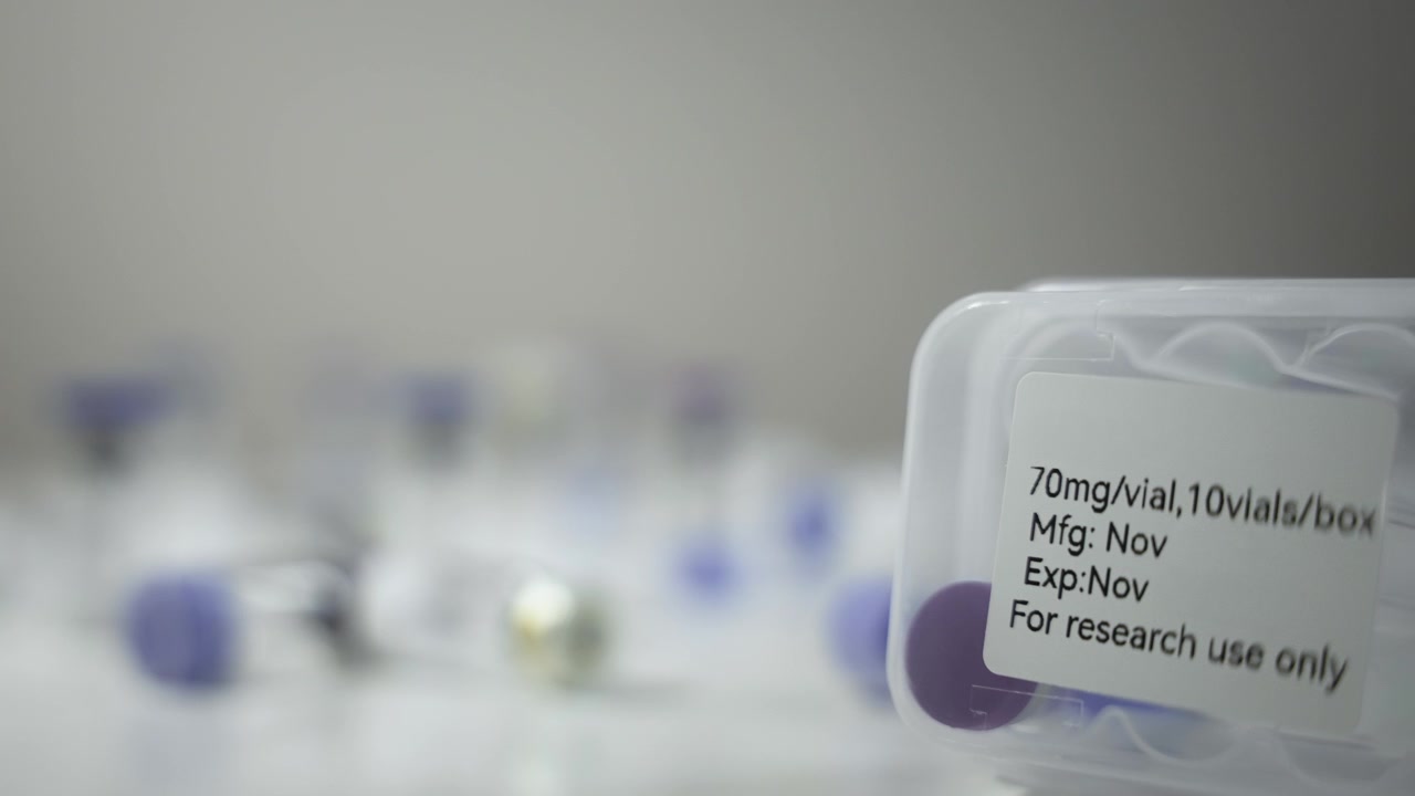 Rack Focus Between Multiple Vials and Storage Case on Table [Peptide Concept]