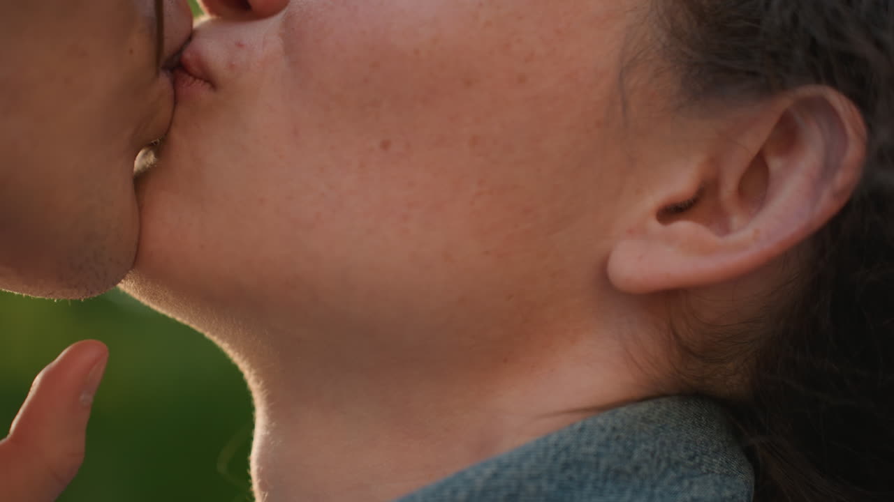 Coppia bianca illuminata dal sole che si scambia sorrisi giocosi all'aperto, controluce soffuso e bagliore caldo, profili in primo piano e risate, sguardi delicati e tocchi affettuosi catturano una connessione gioiosa e speranza.