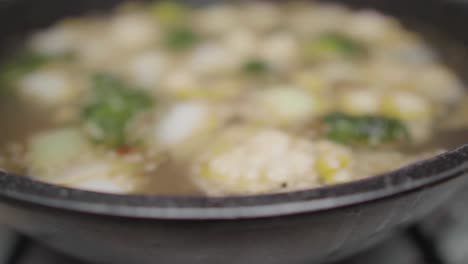 Cámara-Lenta-Revela-Sopa-De-Verduras-Picadas-Cocinando-En-Una-Olla-De-Piedra-De-Caldo