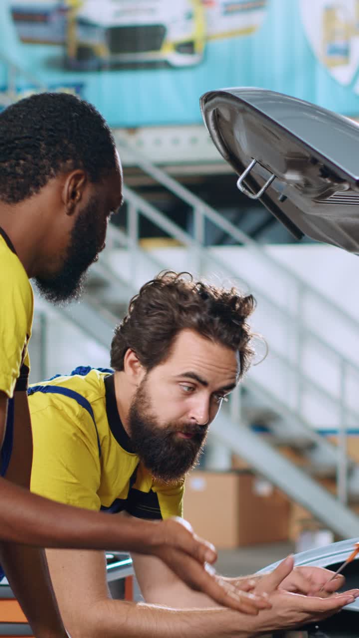 Vertical video Mechanics working together to fix car