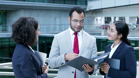 group of smiling business people discussing papers