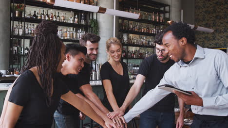 Male-Restaurant-Manager-With-Digital-Tablet-Giving-Team-Talk-To-Waiting-Staff