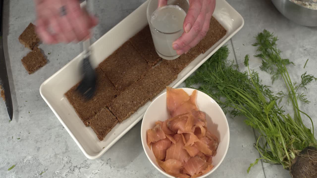 오버헤드 스모르가스타르타 식사 준비에서 호밀 빵에 레몬 주스를 바르다