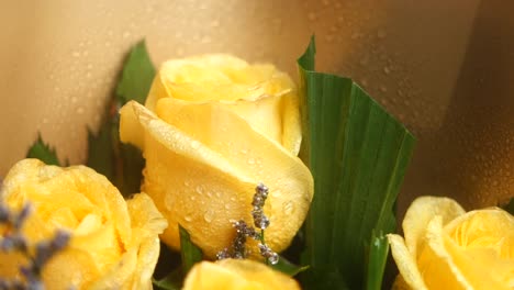 close up of a bouquet of yellow roses with water drops