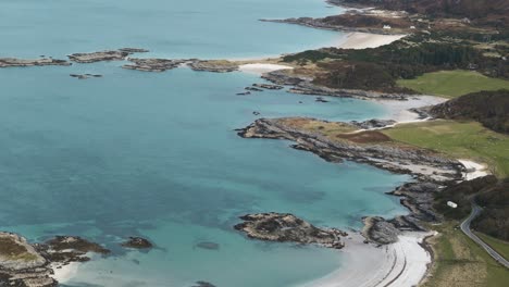 Establishing overview, descending pan up of Traigh Beach, Scotland, with white sand, turquoise waters, and rugged coastline