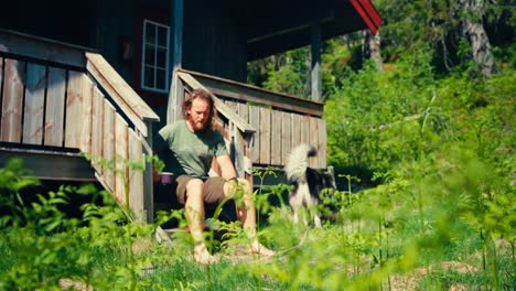 Norwegischer-Typ-Beim-Frühstück-Auf-Den-Stufen-Einer-Holzveranda