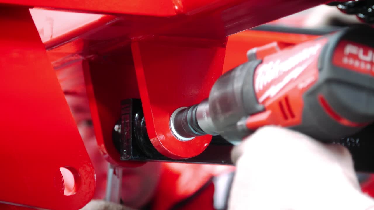 los trabajadores sujetan el perno a ambos lados de la unidad industrial con llave y destornillador