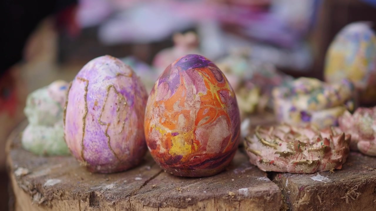 Hand-Painted Decorative Eggs Displayed on a Wooden Stump