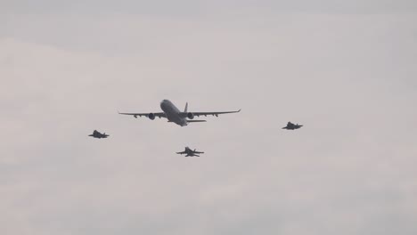 jets fly in formation with a larger aircraft under overcast skies at the avalon airshow in geelong, australia