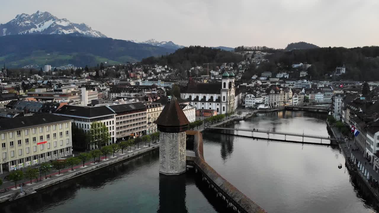 vista aérea de lucerna, suiza con el monte pilatus en el fondo mientras cruza el histórico puente kapellbrücke