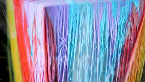 pintura de tinta multicolor fluye lentamente desde el cubo bajo el agua