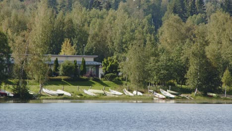 lake landscape with boats, a home and trees in jyväskylä, finland forest