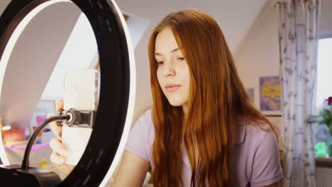una adolescente grabando un video con la luz del anillo.