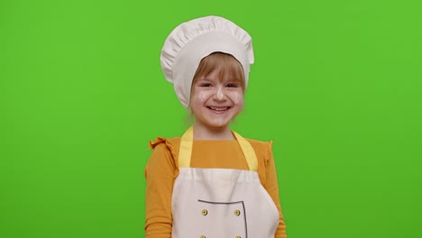encantadora niña vestida como chef cocinero riendo en voz alta después de escuchar una anécdota ridícula