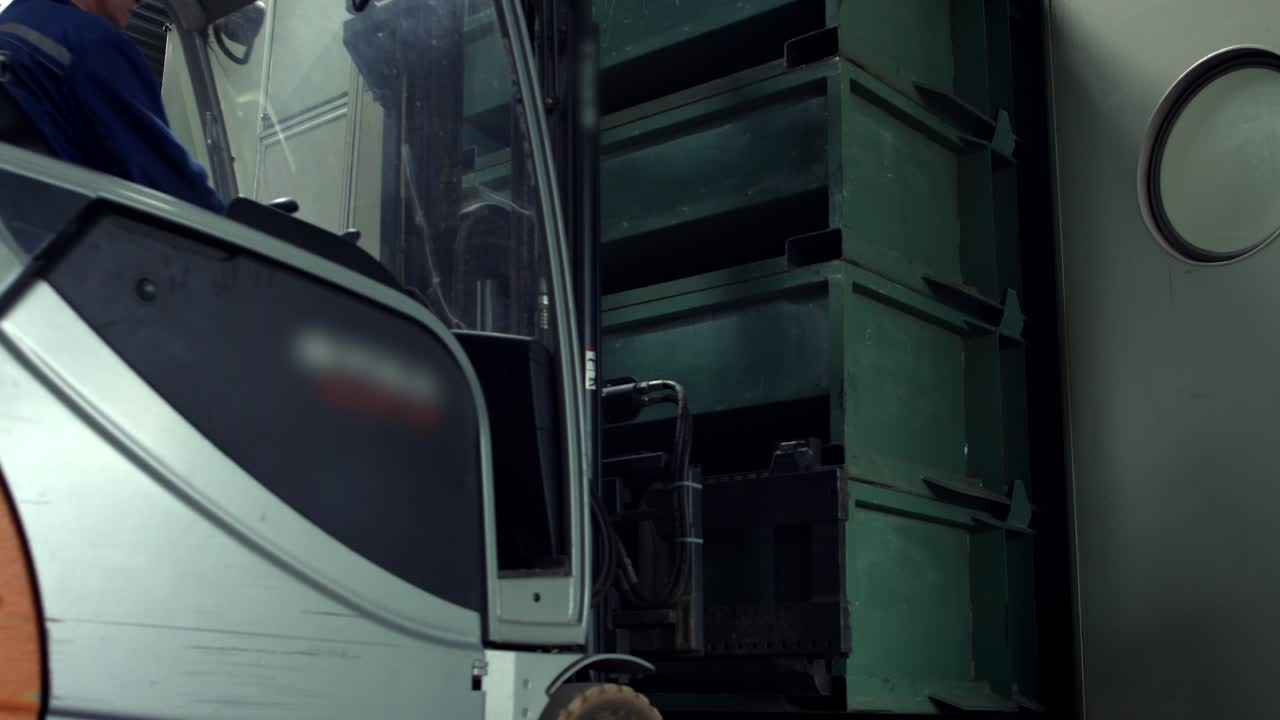 hombre trabajando en un montacargas eléctrico quitando cajas de los estantes en el almacén