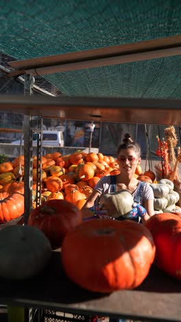 woman selling pumpkins at a market