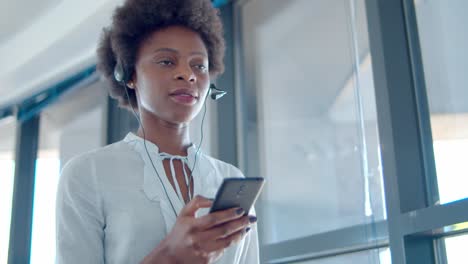 focused female operator in wired headset holding cell