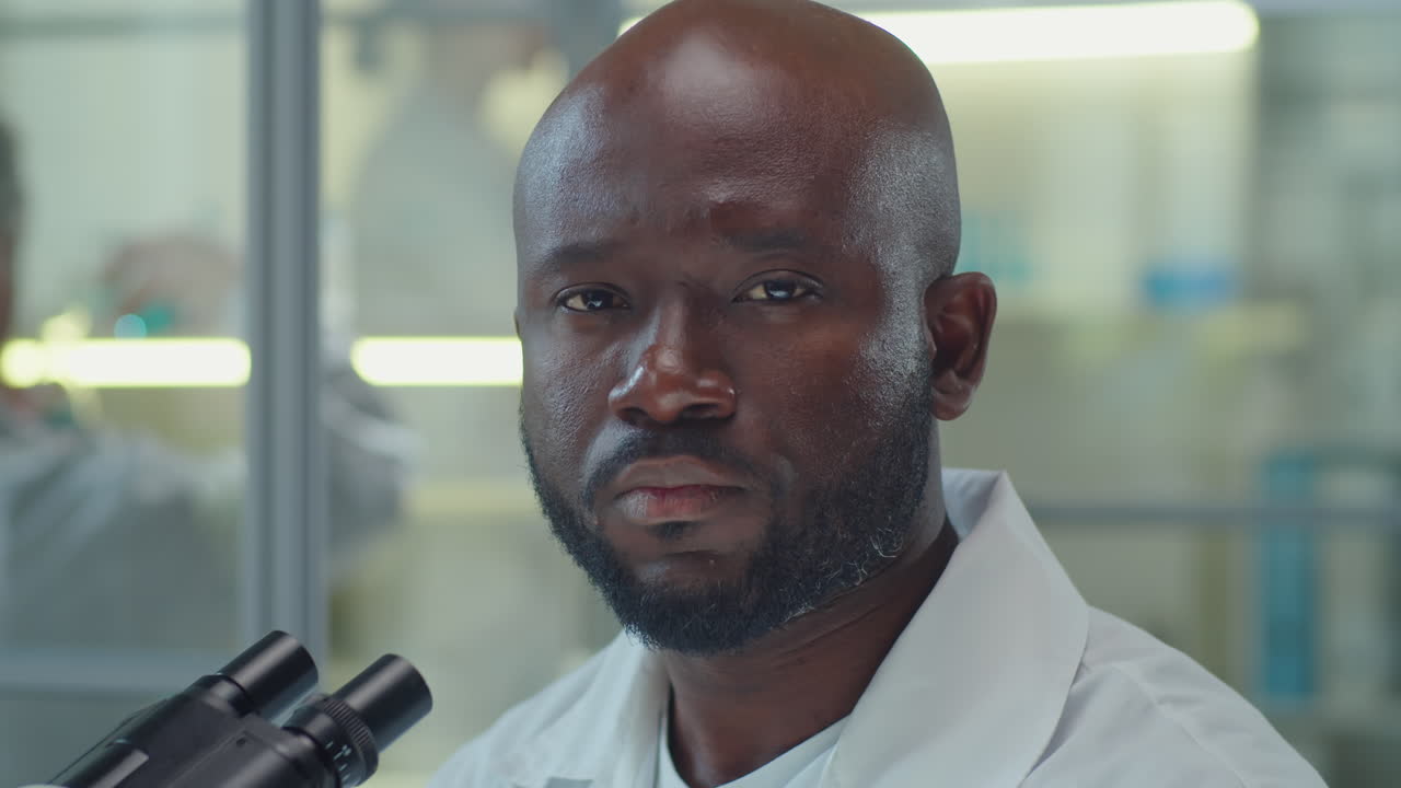 Portrait of African American Man with Microscope in Laboratory