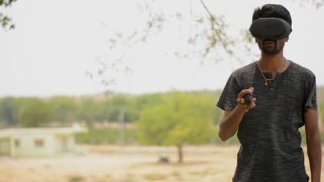 man playing the game in vr headset with remote or controller in hand in the park