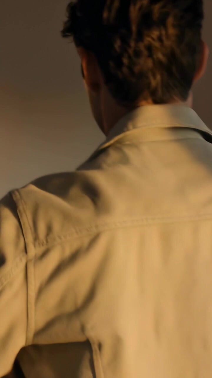 Vertical video: Turning man taking linen jacket at home by doors slipping on sleeves and fixing