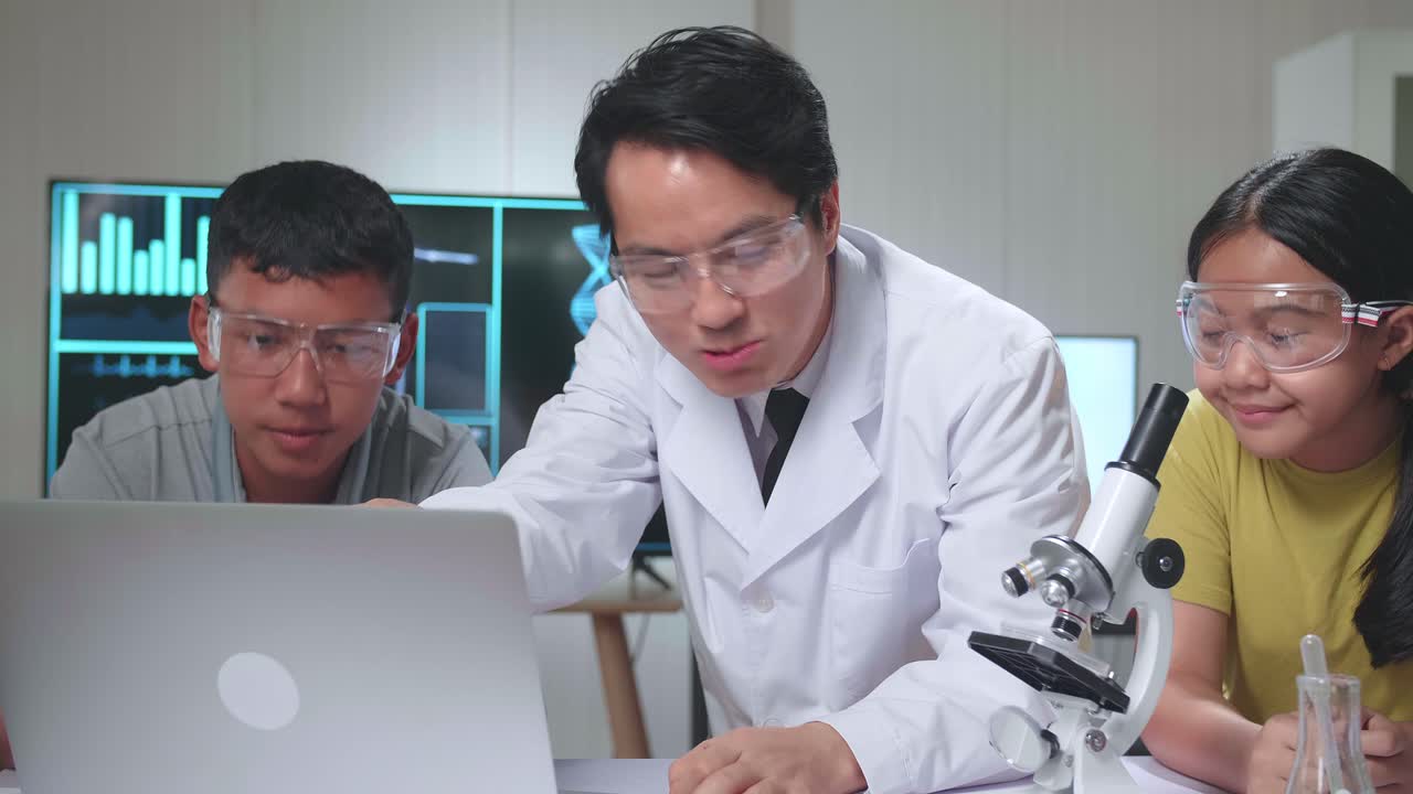 Young Asian Boy And Girl Learning Science Experiment In Laboratory With Teacher In Classroom, Teacher Explain With Laptop Computer