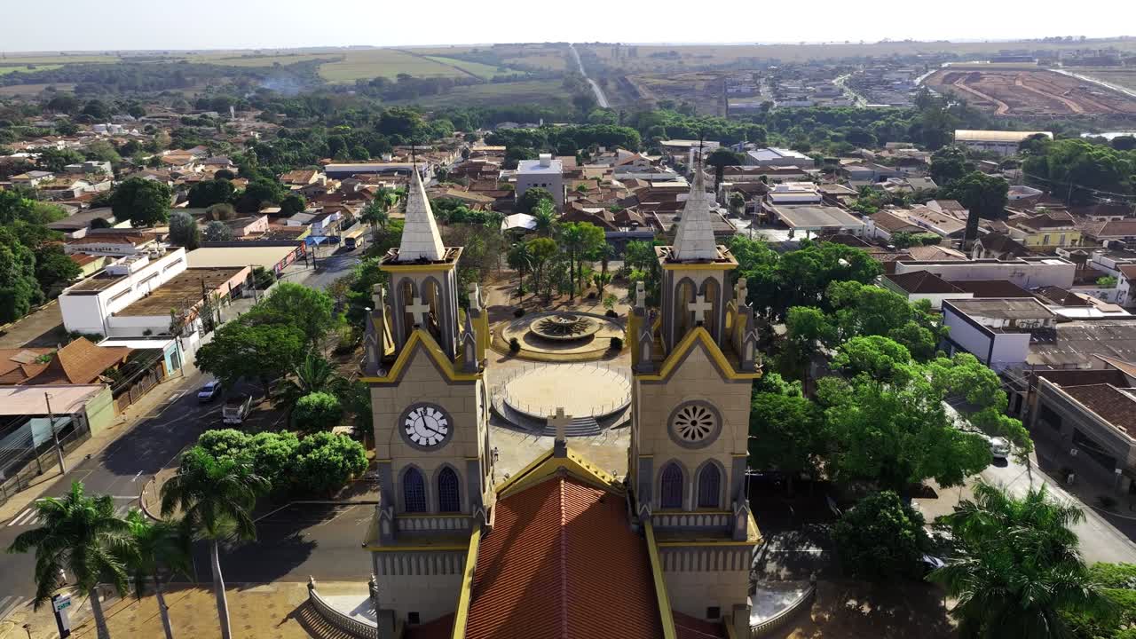 vista aérea de la iglesia matriz de nossa senhora do carmo en frutal, brasil, ubicada junto a una plaza pública en el centro de la ciudad, que mezcla la arquitectura histórica con la vida urbana y la actividad local.