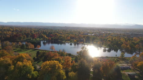 beautiful autumn landscape of wash park with flathead lake and sunlight shining through the water, mountain range in the background, denver, colorado