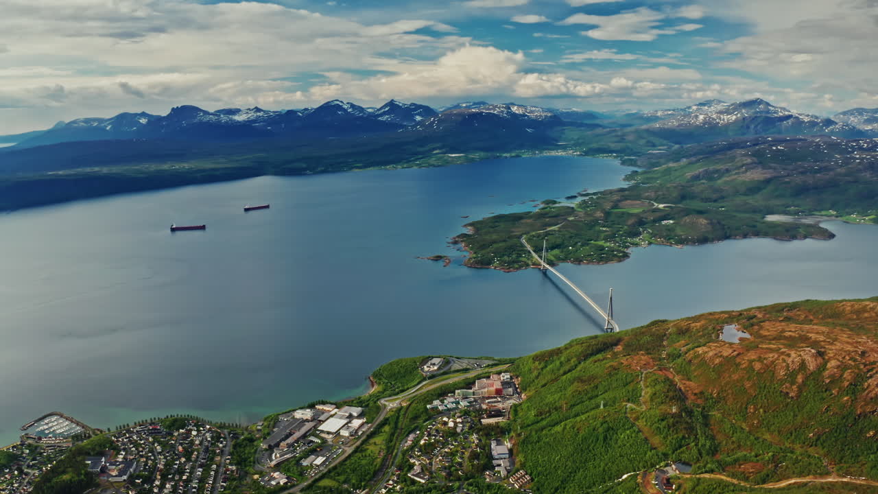 Aerial drone shot over the city of Narvik in Norway. High view of the scenic green landscape, the sea and the nordic fjords.