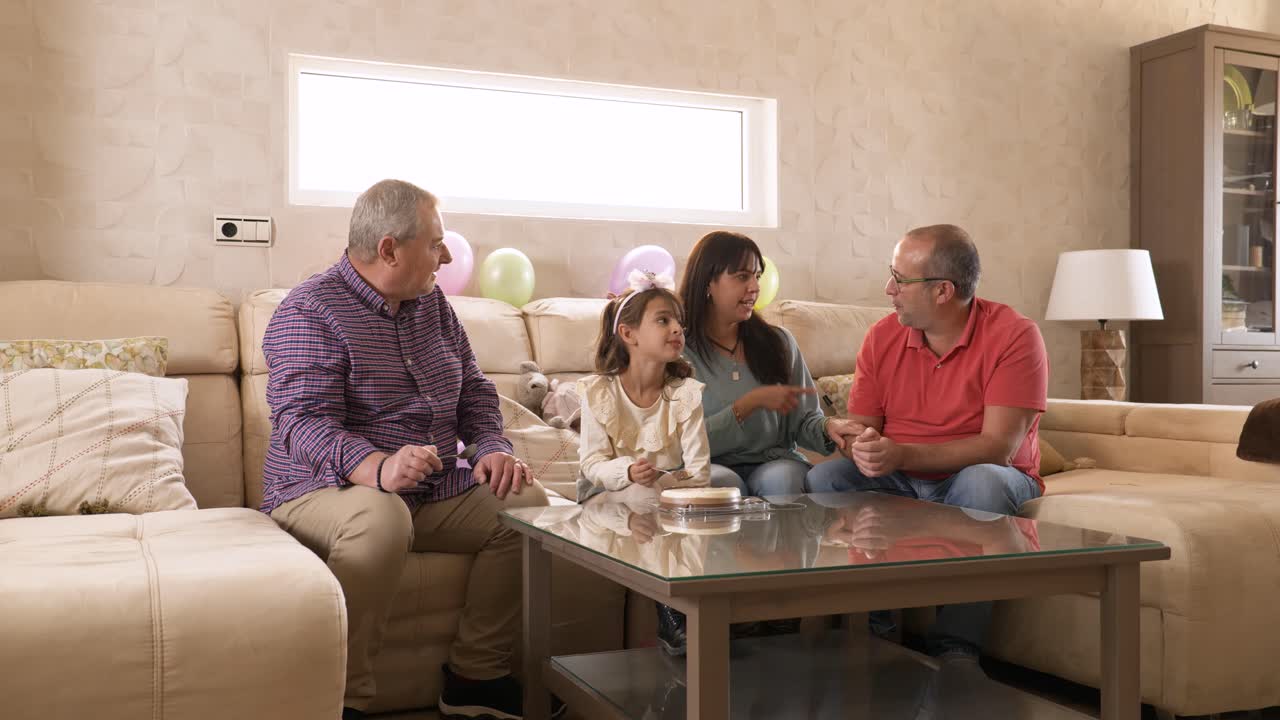 Family sitting on the sofa eating a birthday cake