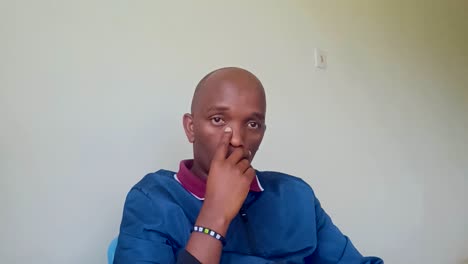 un hombre africano deprimido pensando profundamente tapándose la nariz