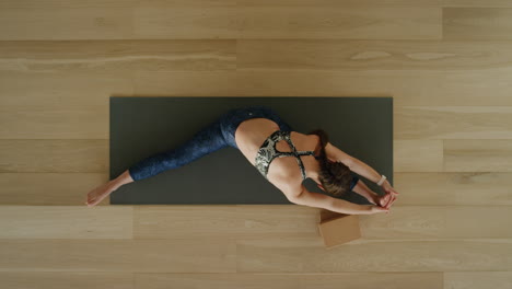 Oben-Gesehene-Yoga-Frau-übt-Seitlich-Sitzende-Weitwinkel-Pose-Im-Trainingsstudio-Und-Genießt-Einen-Gesunden-Lebensstil,-übt-Meditationsübungen-Auf-Einer-Trainingsmatte