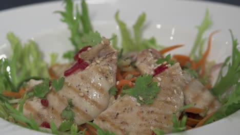 un chef sirviendo una ensalada de pollo